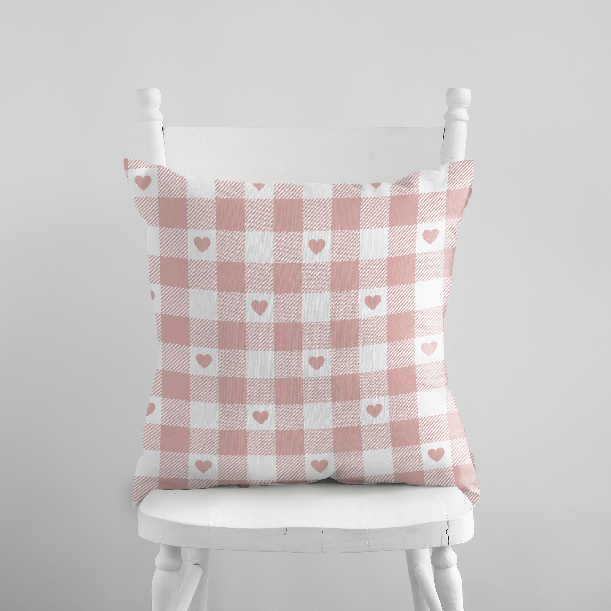 Valentine Pink Gingham Hearts PILLOW on a white chair – soft blush checkered cushion cover.